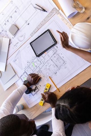 Team Collaborating on Architectural Blueprints and Digital Tools