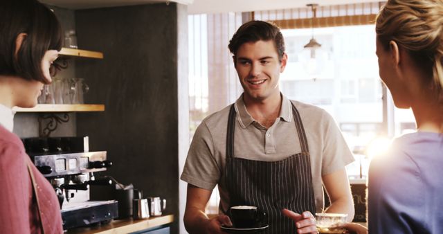 Barista serving coffee to customers in cozy cafe - Download Free Stock Images Pikwizard.com