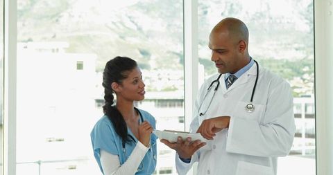 Doctor and nurse reviewing clinical data on tablet demonstrating healthcare teamwork