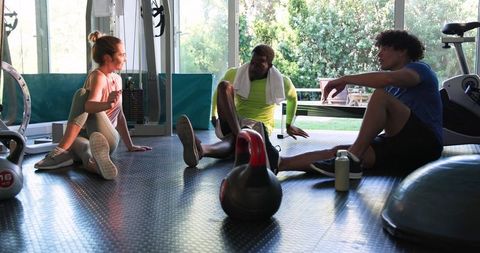 Friends Relax After Intense Gym Workout with Kettlebell