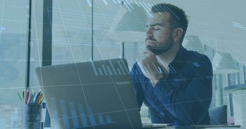 Contemplative businessman analyzing laptop data with digital graphs overlay in urban office