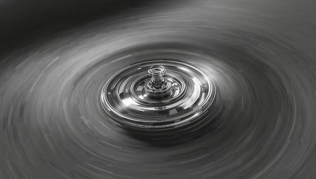 Spinning chrome top forming radial motion blur and concentric reflective rings