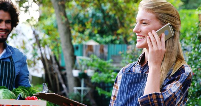 Smiling Female Vendor Talking on Phone at Farmers Market - Download Free Stock Images Pikwizard.com