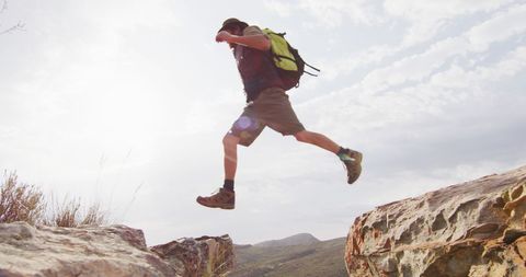Adventurous Hiker Jumping Over Rocky Mountain Ravine - Download Free Stock Images Pikwizard.com