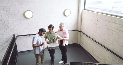 Diverse Coworkers Collaborating on Office Stair Landing