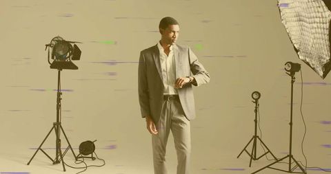 Elegant male model checking watch in professional studio