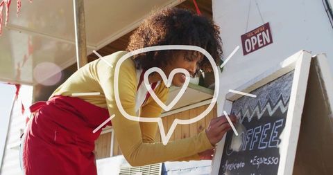 Barista Writing on Chalkboard at Outdoor Coffee Cart