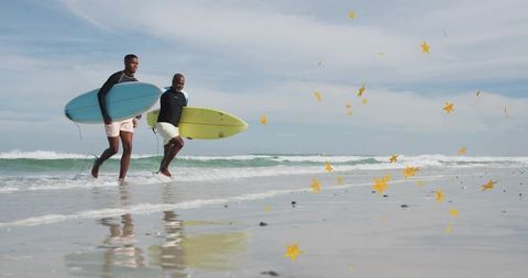 Running surfers carrying blue and yellow boards on wet-sand shoreline with star confetti