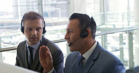 Caucasian Businessmen Collaborating with Headsets in Modern Office