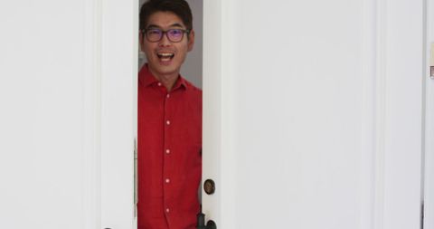 Happy Man in Red Shirt Greeting Visitor at Door