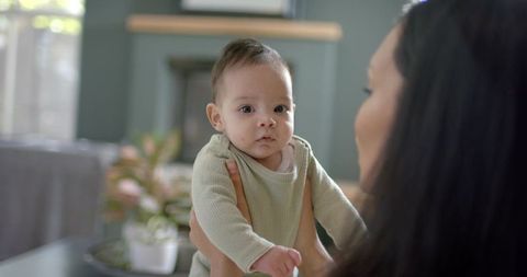 Mother holding baby in tranquil living room setting