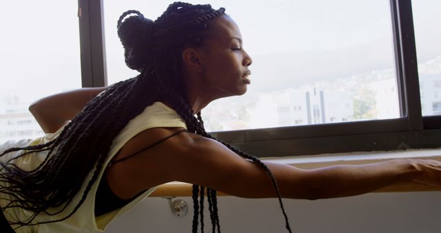 Focused Young Woman Stretching by Window in Gym - Download Free Stock Images Pikwizard.com