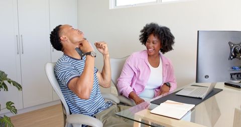Cheerful Couple Collaborating on Home Office Project