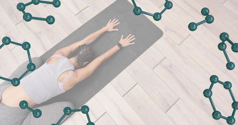 Overhead woman stretching on dark yoga mat with braided hair, smartwatch and teal overlays
