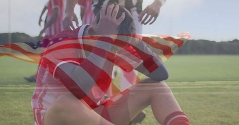 Despondent soccer player comforted by teammates under flag overlay