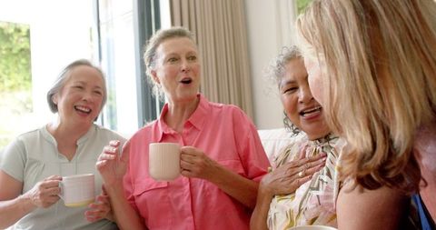Laughing Senior Women Socializing Indoors
