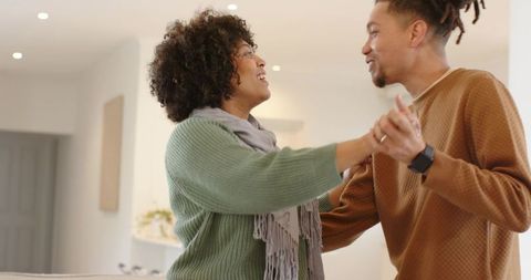 Couple Holding Hands Swaying in Cozy Living Room, Intimate Home Romance