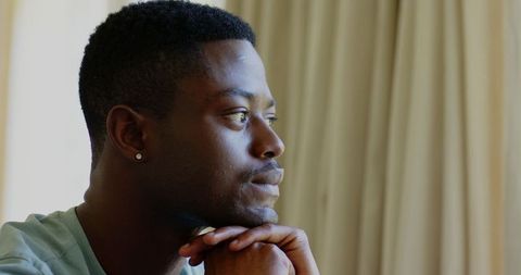 Thoughtful african american man contemplating by window