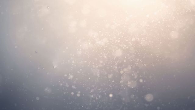 Soft golden bokeh dust particles backlit gradient background evoking ethereal glow