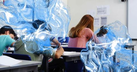 High school students writing in classroom with blue digital distortion overlay and focus
