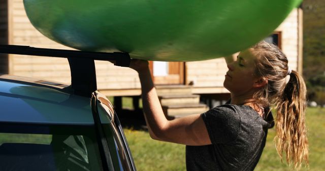 Woman Loading Kayak onto Car Roof Near Wooden Cabin - Download Free Stock Images Pikwizard.com