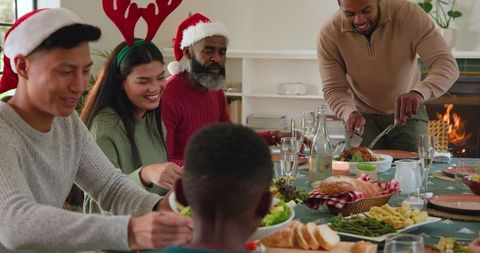 Festive Family Gathering at Holiday Feast with Antlers and Santa Hats