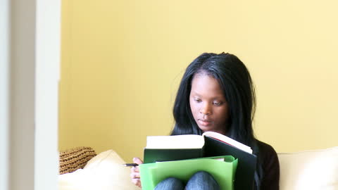 Young Woman Reading Book at Home in Relaxed Setting