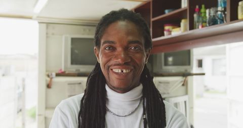 Happy african hairdresser smiling in township salon