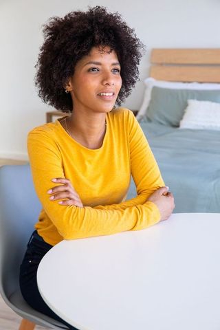 Relaxed Woman in Cozy Bedroom with Mustard Top