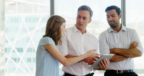 Diverse Business Team Collaborating on Digital Tablet in Modern Office