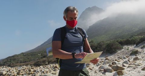 Senior Hiker Wearing Mask Reading Map Beach Adventure