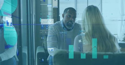 Manager Leaning Forward Gesturing to Colleague While Reviewing Transparent Data Dashboard