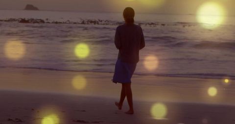 Serene Woman Walking Beach at Sunset with Dreamy Light Flares