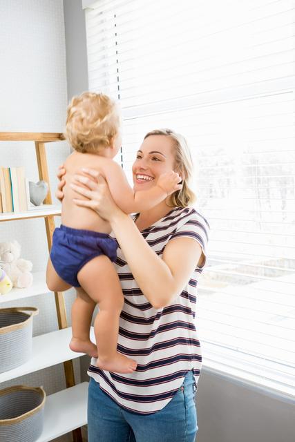 Happy Mother Holding Baby Boy in Bright Room - Download Free Stock Photos Pikwizard.com