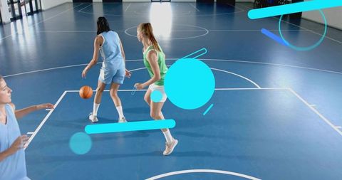 Young female athletes dribbling on indoor basketball court during team drill with defender