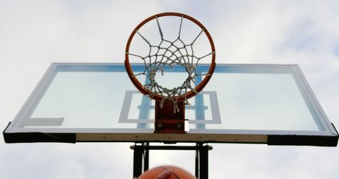 Basketball Player Aiming Hoop Against Sky