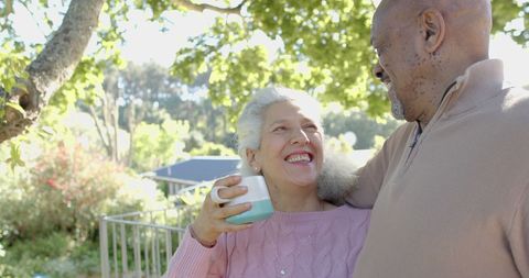 Happy Senior Couple Enjoying Morning Coffee on Balcony