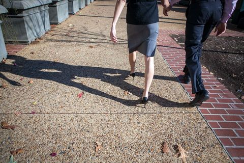 Couple Walking on Sunny Sidewalk with Fallen Leaves