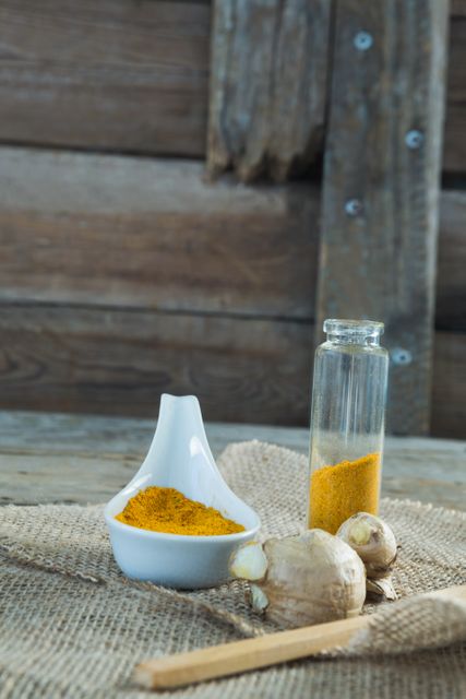 Close-up of turmeric powder and ginger on sackc