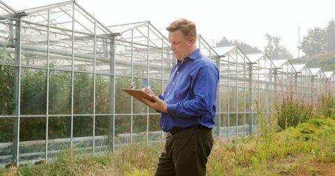 Agricultural Manager Reviewing Greenhouse Operations with Clipboard - Download Free Stock Images Pikwizard.com