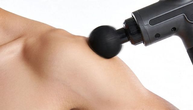 Percussion massage gun delivering deep tissue relief to shoulder and trapezius muscles