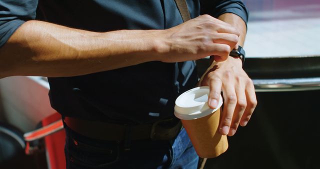 Man checking time while holding takeaway coffee cup - Download Free Stock Images Pikwizard.com