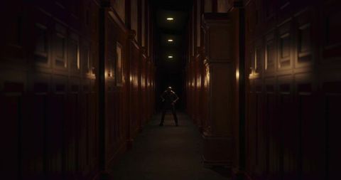 Backlit Executive Standing in Dim Wood-Panelled Corridor Emphasizing Power and Mystery