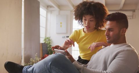 Diverse Creatives Collaborating on Tablet in Casual Office