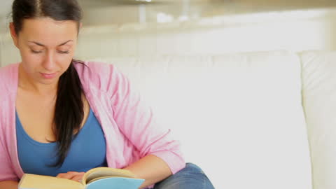 Woman Relaxing and Enjoying a Book on Comfortable Sofa