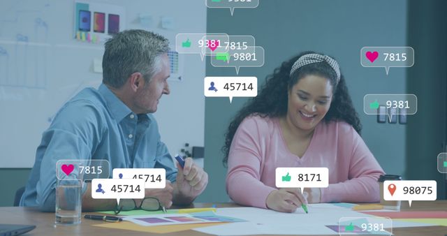 Two coworkers are collaborating in a modern office with social media engagement metrics overlaid on the scene. The photo highlights the integration of social media insights in business planning and teamwork, ideal for use in digital marketing, corporate presentations, and team collaboration features.