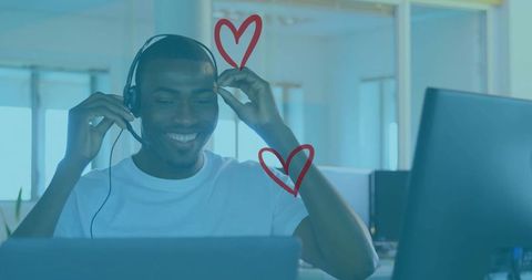 Smiling man communicating in office with headset and laptop