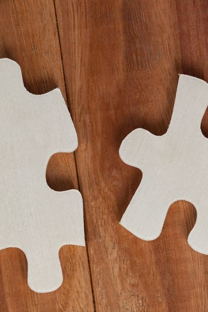 Two Jigsaw Puzzle Pieces on Wooden Background - Download Free Stock Photos Pikwizard.com