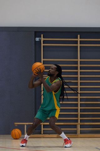 Athlete Practicing Basketball Skills on Indoor Court