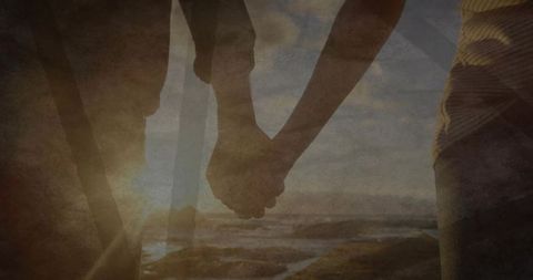 Couple Holding Hands Strolling Beach at Sunset